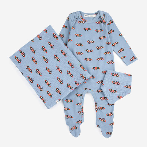 Baby outfit set with blue and red race car patterned footie, bandana, and blanket on a white background