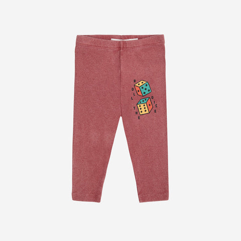 Rust colored baby leggings with colorful dice design on a white background